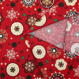 Popelina de algodón estampada con medallones navideños y copos de nieve sobre fondo rojo
