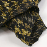 Gold houndstooth wool blend tweed on black background