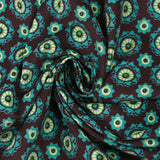 Cotton corduroy printed with turquoise rosettes and brown background