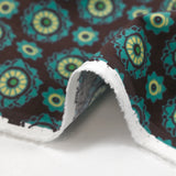 Cotton corduroy printed with turquoise rosettes and brown background