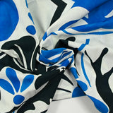 Voile de algodón con estampado de arabescos azules y negros sobre fondo blanco.