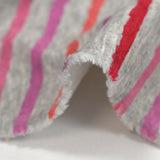 Sudadera de peluche a rayas rojas, rosas y violetas con fondo gris jaspeado