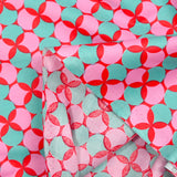 Coated poplin printed with polka dots & green clover on a red background