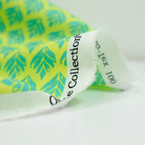 Coated poplin with turquoise vegetable print on lemon background