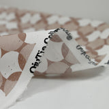 Coated poplin printed with white polka dots & clover on a glossy brown background
