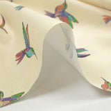Algodón estampado con un vuelo de colibríes sobre fondo crudo