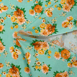 Cotton poplin printed with orange bouquet on a water green background