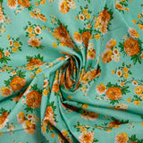 Cotton poplin printed with orange bouquet on a water green background