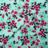 Cotton poplin printed with floral clusters on a water green background