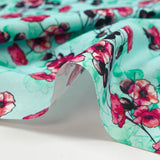 Cotton poplin printed with floral clusters on a water green background