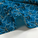 Cotton poplin printed with floral gesture on a petrol blue background