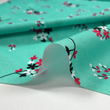 Cotton poplin printed with floral breath on aqua background