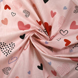 Cotton poplin printed with lots of hearts on a light pink background