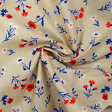 Cotton poplin printed with blue, white and red flowers on a greige background