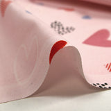 Cotton poplin printed with lots of hearts on a light pink background