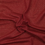 Jersey de poliéster iridiscente dorado con fondo rojo.