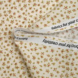 Cotton poplin printed with abstract flowers on an ecru background