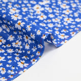 Viscose printed with white and yellow flowers, blue background