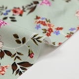 Cotton poplin printed with purple arabesque flower and green-gray background