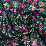 Algodón gráfico estampado floral verde bosque y fondo negro fucsia
