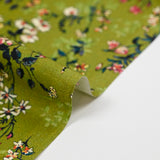 Cotton poplin printed with an idyllic flower on an apple green background
