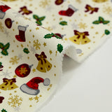 Popeline de coton imprimée bonnets du Père Noël, chaussettes et houx fond écru