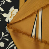 Twill de polyester satiné imprimé fleurs écrues et bordure ocre fond noir