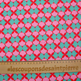 Coated poplin printed with polka dots & green clover on a red background