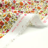 Coton imprimé Greta fleurs fuchsia et orange fond blanc au mètre