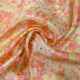 Silk satin printed with coral pink flowers on a pastel green background