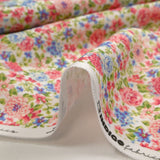 Cotton piqué printed with Sarah's flowers in blue and strawberry on a white background