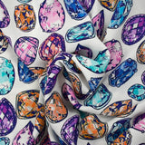 Viscose crepe with precious stone print on white background