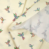 Algodón estampado con un vuelo de colibríes sobre fondo crudo