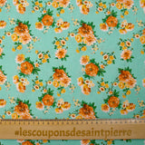 Cotton poplin printed with orange bouquet on a water green background