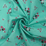 Cotton poplin printed with floral breath on aqua background