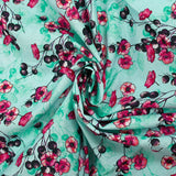 Cotton poplin printed with floral clusters on a water green background