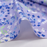 Cotton poplin printed with forget-me-not clouds, lavender background