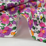 Cotton poplin printed mist of purple and pink flowers on white background