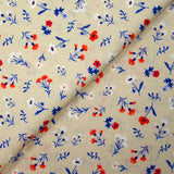 Cotton poplin printed with blue, white and red flowers on a greige background