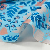Cotton poplin printed with floral happiness on a sky blue background