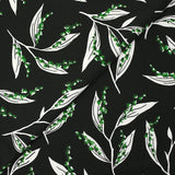 Satin viscose knit printed with a sprig of lily of the valley, black background