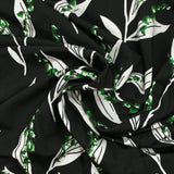 Satin viscose knit printed with a sprig of lily of the valley, black background
