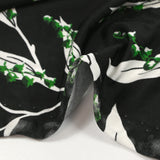 Satin viscose knit printed with a sprig of lily of the valley, black background