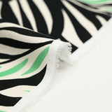 Cotton satin with green and white tribal jungle print, black background