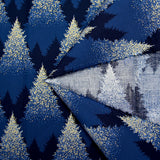Popelina de algodón estampada con abetos brillantes sobre fondo azul medianoche