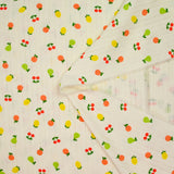 Punto pointelle de algodón con fondo tutti frutti blanquecino